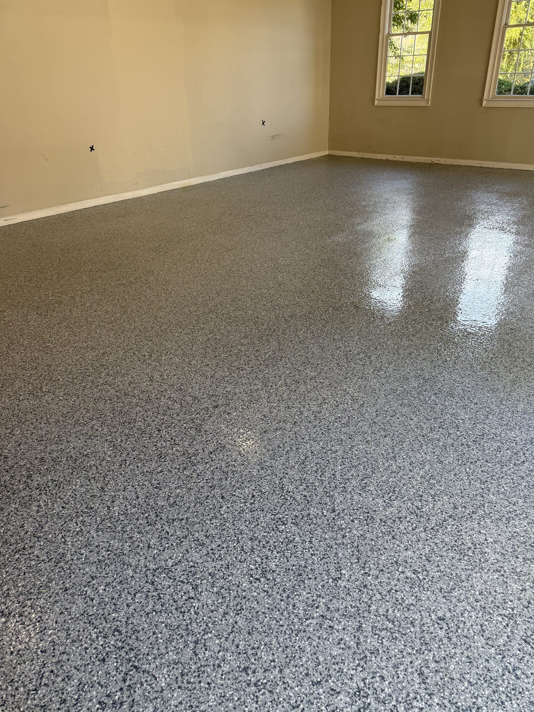Glossy gray flake epoxy floor in a finished garage