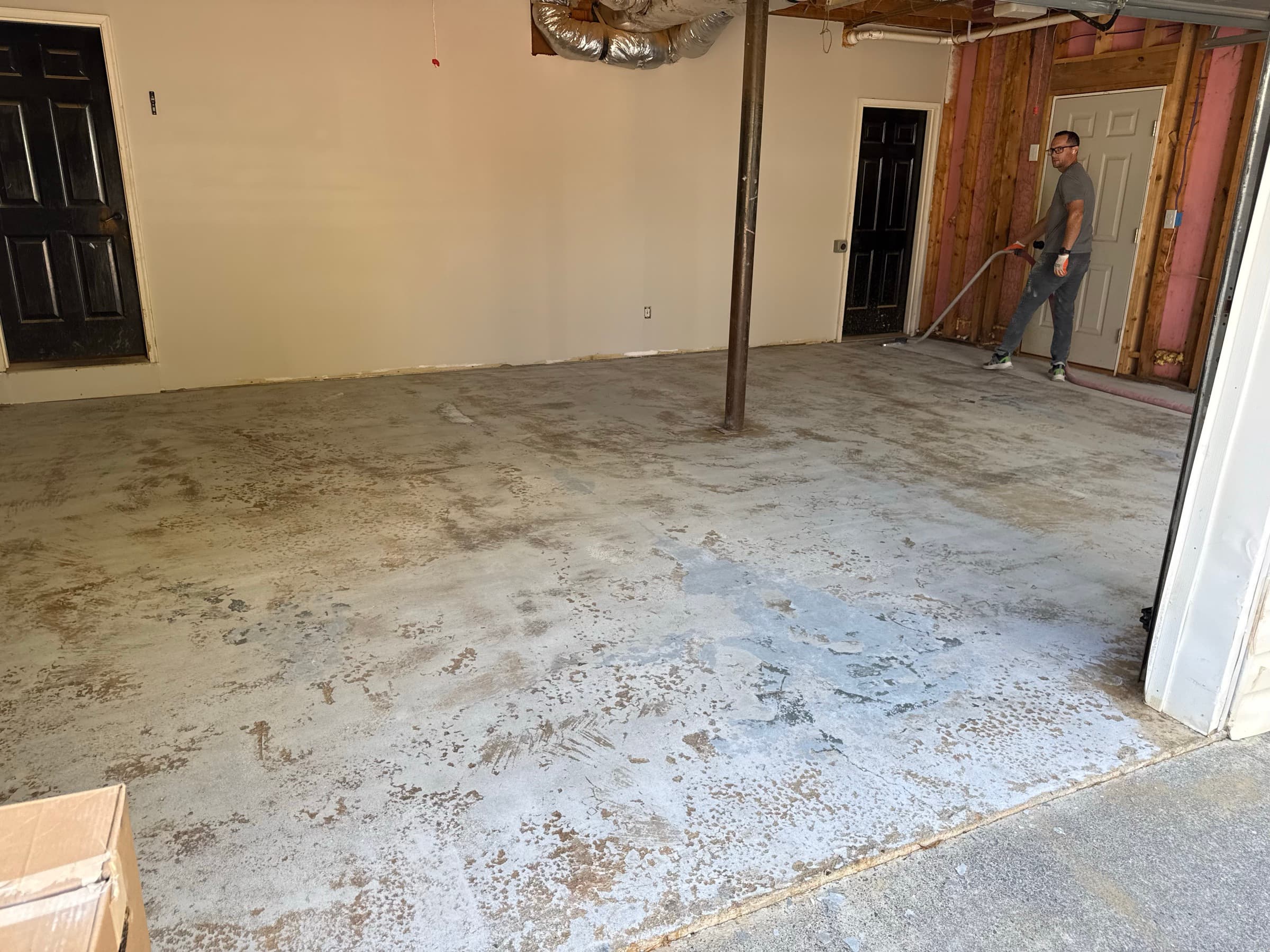 Bare stained concrete garage floor before epoxy coating