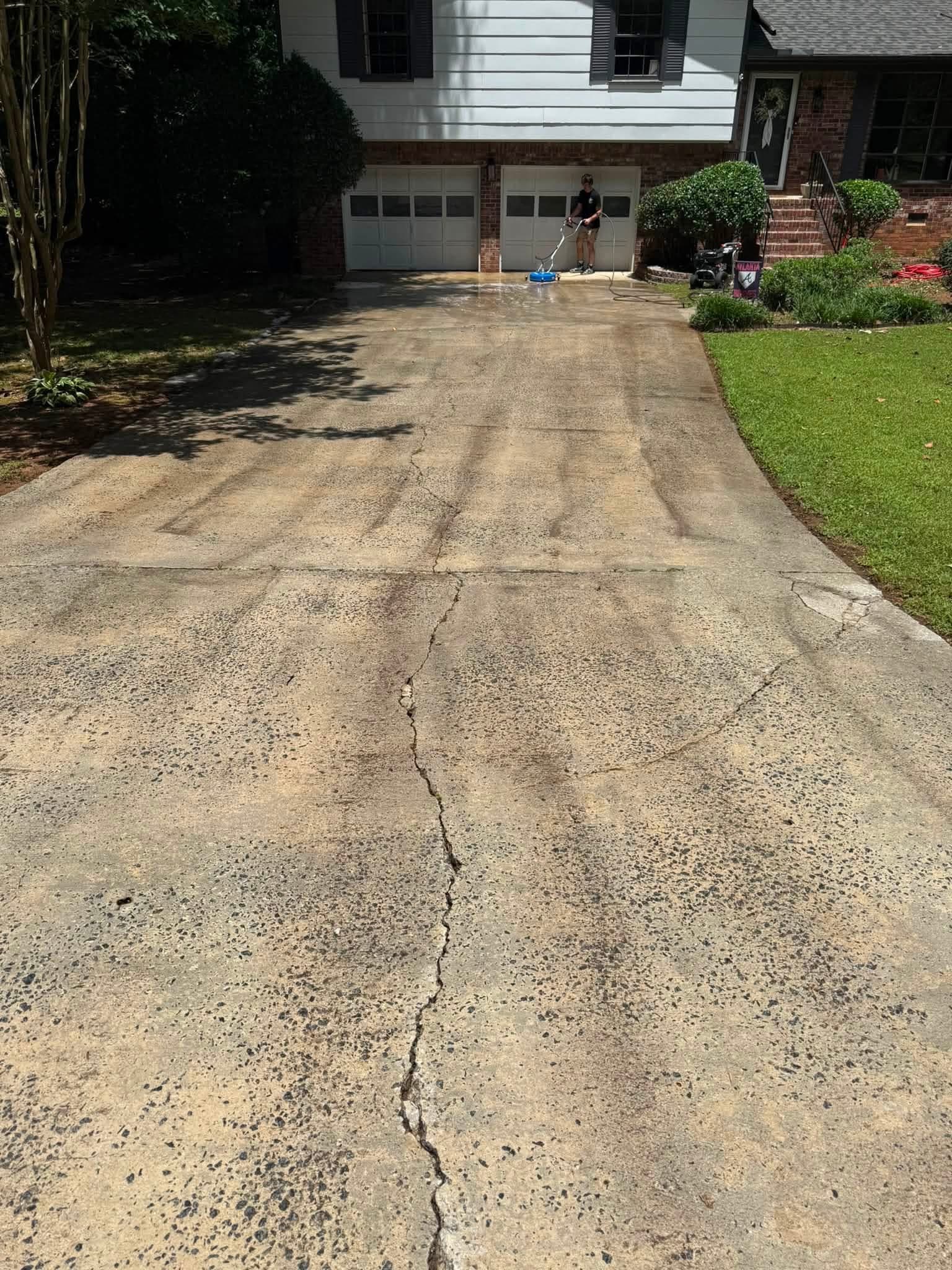 Concrete driveway stained with algae and dirt before pressure washing