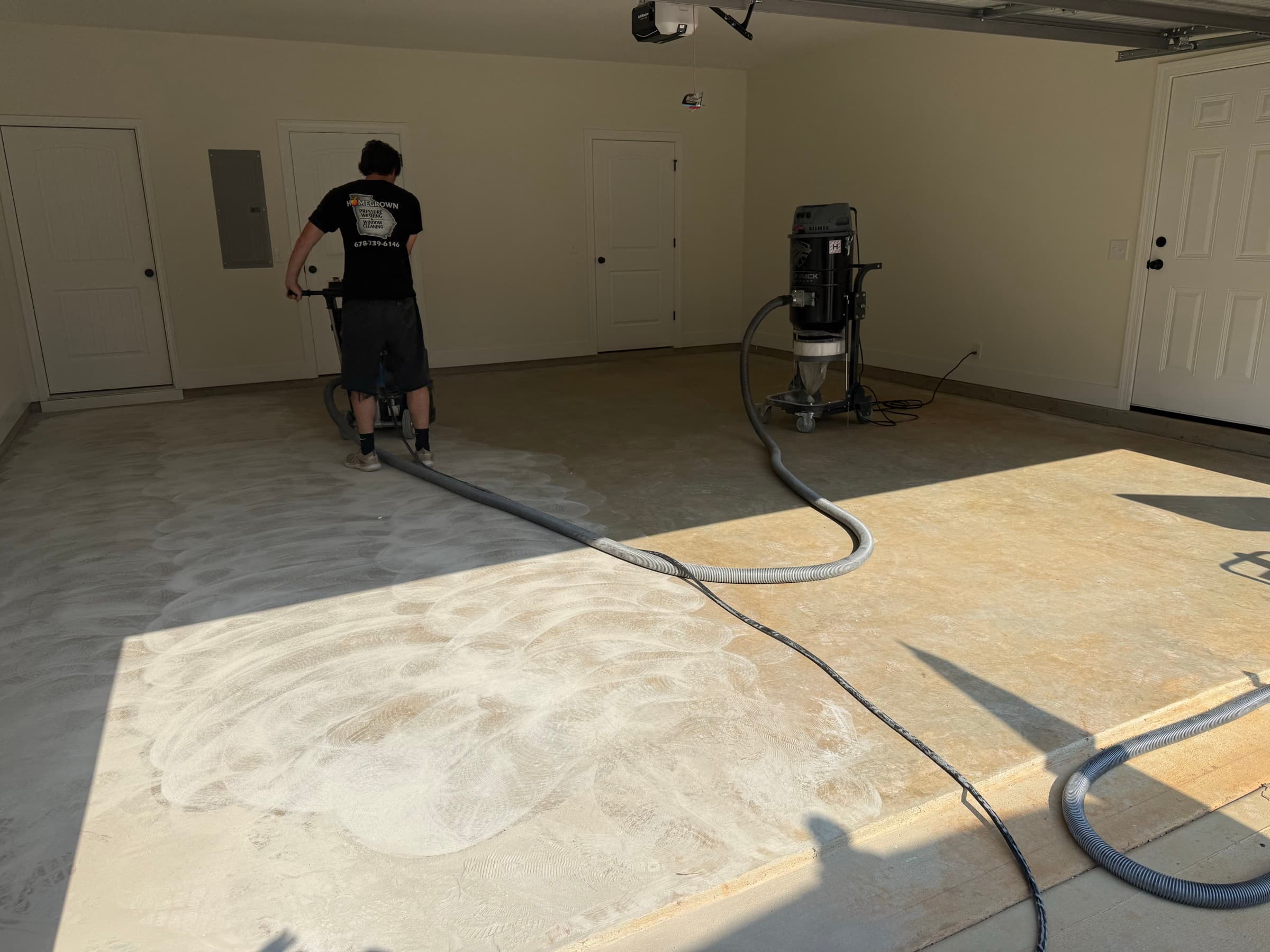 Homegrown Epoxy crew member grinding a garage floor to prep for coating